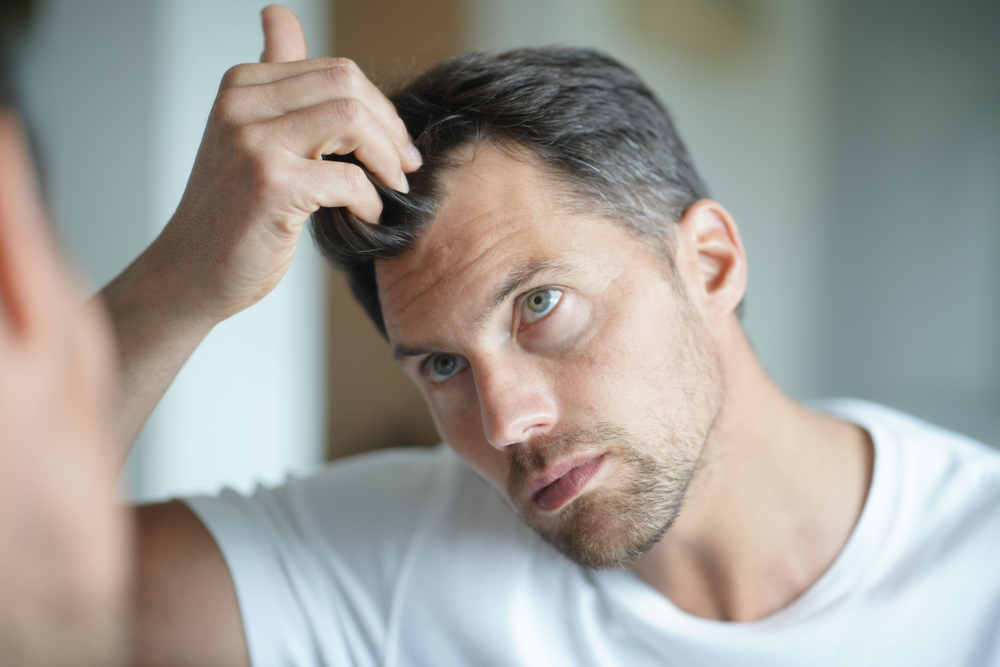 mann besorgt über Haarausfall